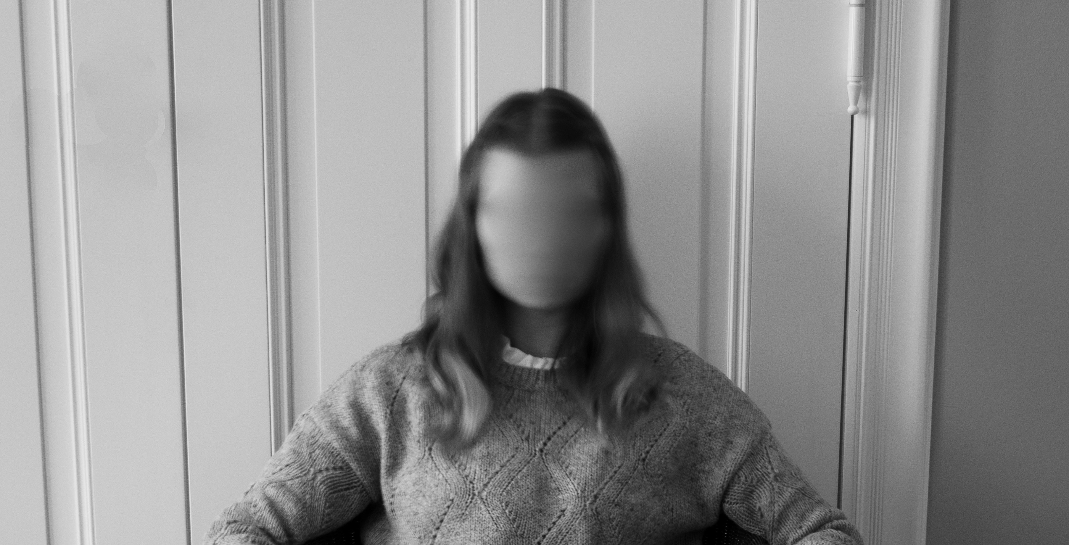 Black and white image of a woman with her face blurred