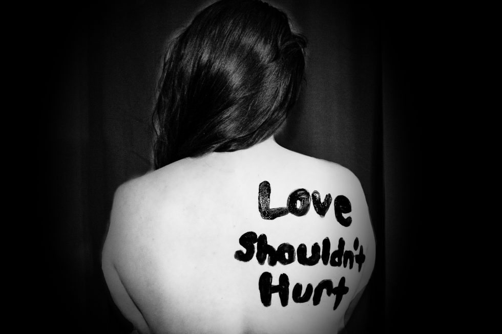 Love shouldn't hurt written on a girl's back